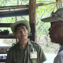 A younger guide listening to Woody and the former Viet Cong soldier talk. 